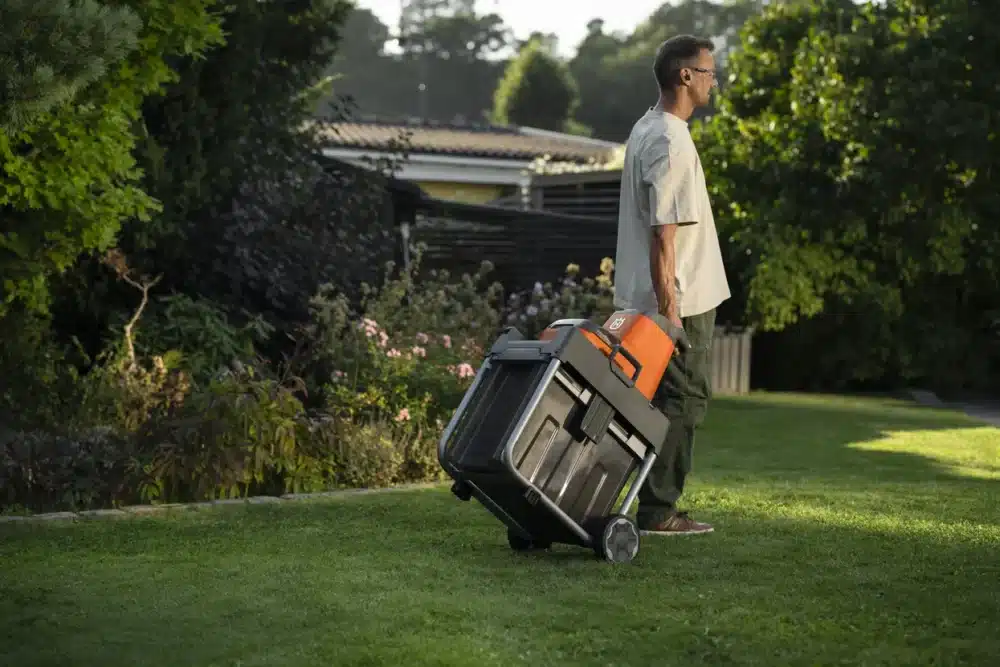 a man carrying a tool box on a lawn