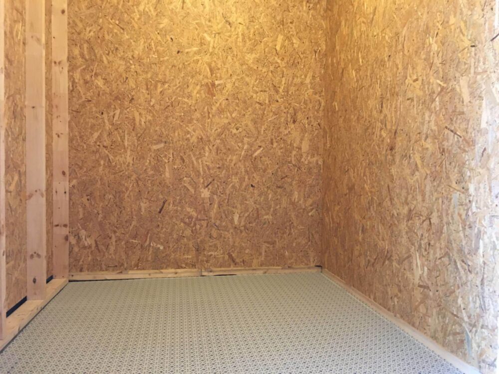 Et tomt rum med vægge og gulv af træplader.