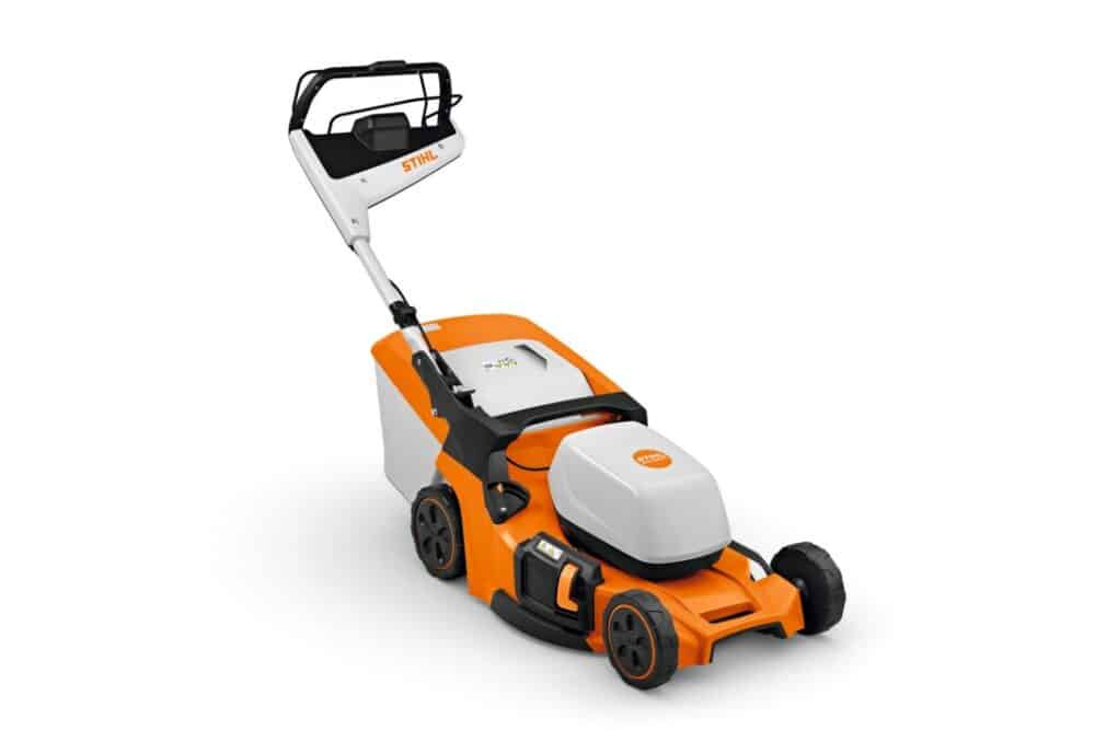 En orange og hvid plæneklipper med mærket STIHL på håndtaget. Den har sorte hjul og et ergonomisk håndtag. Designet er moderne og kompakt, ideel til græsslåning i hjemmet.