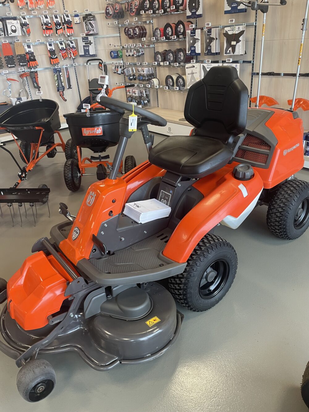 Rød plænetraktor udstillet i butik