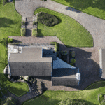 Luftfoto af et hus med tilhørende have og indkørsel