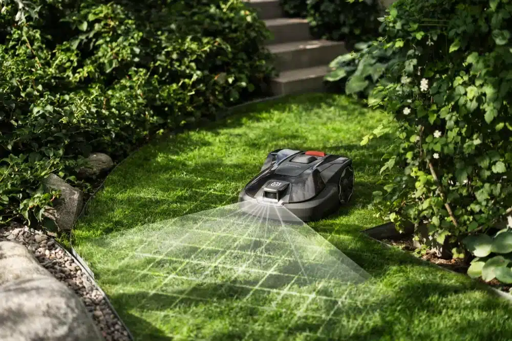 Robotplæneklipper på græsplæne med sensorer.