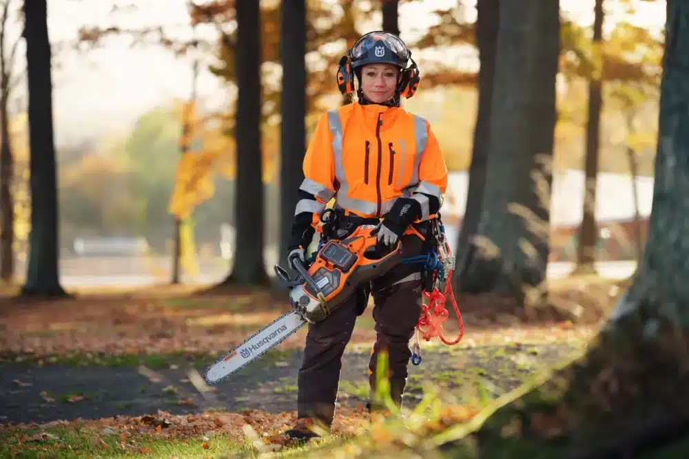 Person i skovningsdragt holder en motorsav.