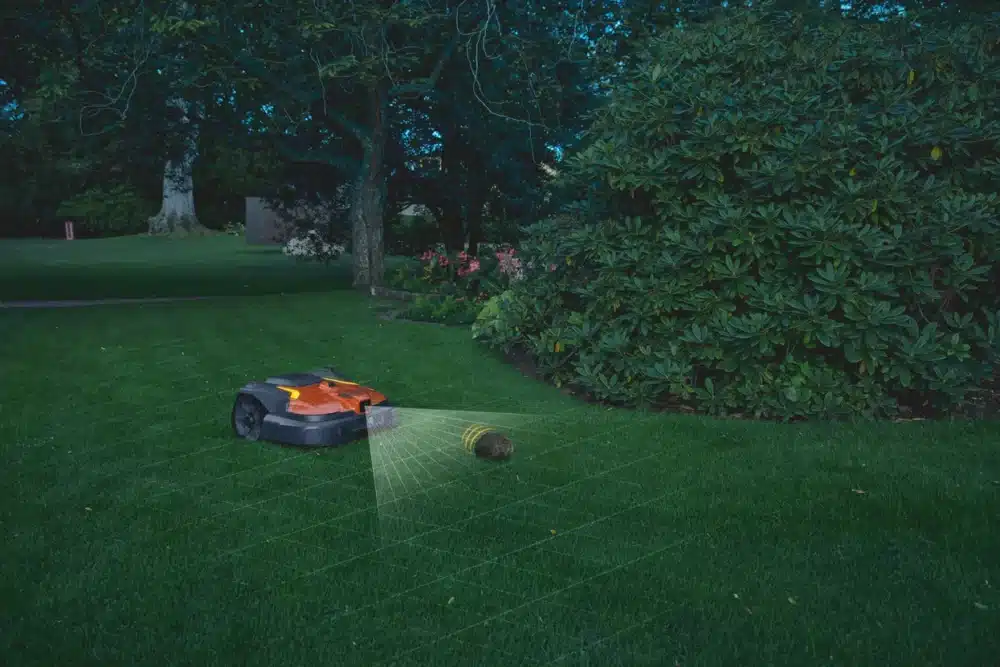 Robotplæneklipper på en græsplæne om natten.