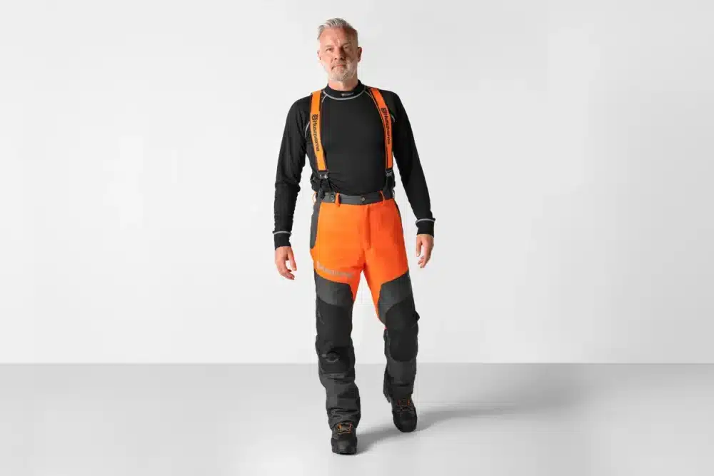 Mand i orange sikkerhedsbukser med seler