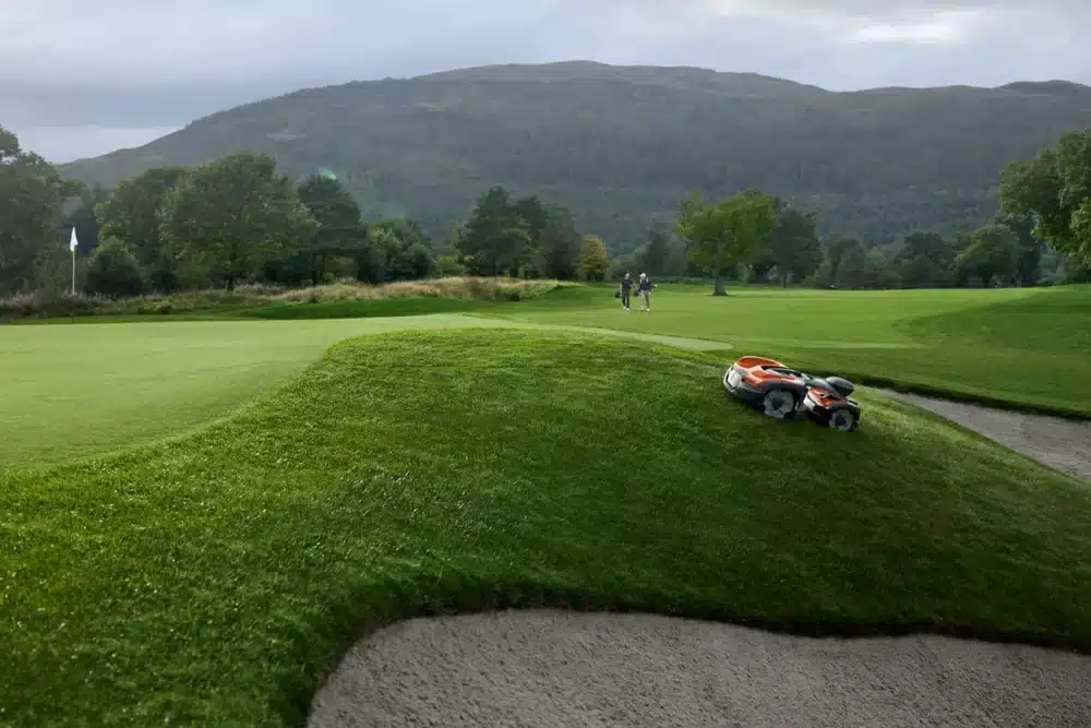 Robotplæneklipper på en golfbane bakke.